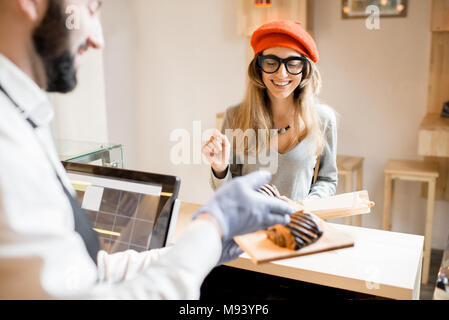 Frau kauft ein Croissant Stockfoto