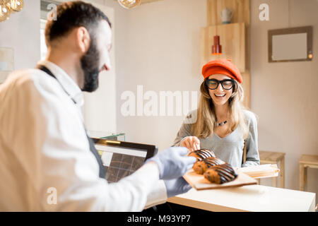 Frau kauft ein Croissant Stockfoto