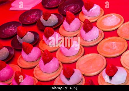 Erdbeere Mochi (Ichigo Daifuku) ist ein weich und zäh Mochi gefüllt mit frischem saftigen Erdbeeren und süßen roten bean Paste auf eine Holzplatte. Stockfoto