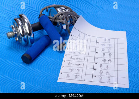 Sport Fitness Zubehör auf Blau Gymnastikmatte. Tabelle der gymnastischen Übungen mit weißen Raum. Stockfoto