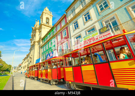 Braga, Portugal - 12. August 2017: rote Bummelzug entlang der Avenida Central neben Kloster von Congregados oder Kloster der Kongregation in städtischen Zentrum von Braga, eine der ältesten Städte von Portugal Stockfoto