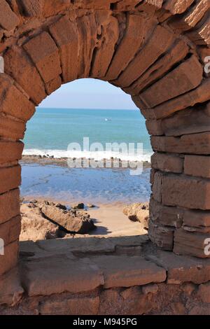 Das Meer in Blau und Türkis ist flüchtig dachte, einer alten gewölbten Stein Portal Stockfoto