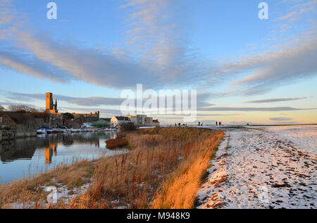 Winter verschneite Ansicht von St Andrews Hafen und Kathedrale von der Kante des Ostens Sande in Fife, Schottland Stockfoto