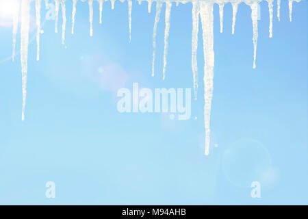 Schmelzenden Eiszapfen mit Wassertropfen gegen den blauen Himmel auf sonniger Frühlingstag Hintergrund Stockfoto