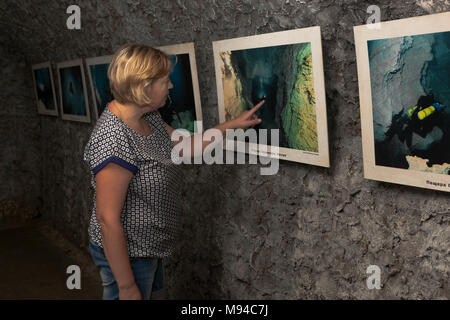 Gelendschik, die Region Krasnodar, Russland - 15. Juli 2015: Frau untersucht eine Foto- ausstellung in einer der dunklen Hallen Höhlen Bear Safari Park in Gelendschik Stockfoto