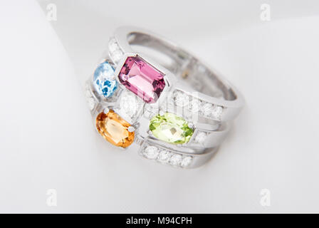 White Gold Ring mit Citrin Peridot, blautopas, rosa Turmalin und Diamanten auf weichen, weißen Hintergrund Stockfoto