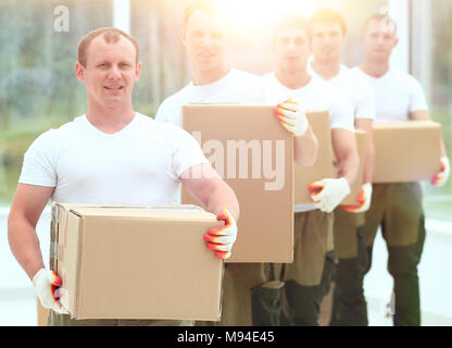 Team von Bauherren mit Boxen von Baustoffen Stockfoto
