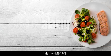 Frischer Salat mit gegrilltem Lachs filet auf weissem Holztisch. Ansicht von oben kopieren Raum Stockfoto
