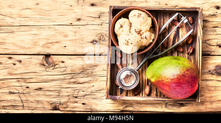 Eis, mango Obst und ein Löffel für Speiseeis in Holz- fach Stockfoto