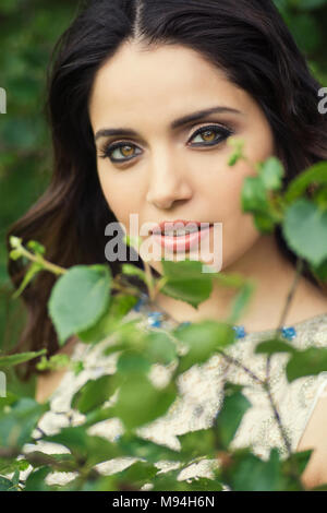 Schöne junge Frau, die im Garten Stockfoto