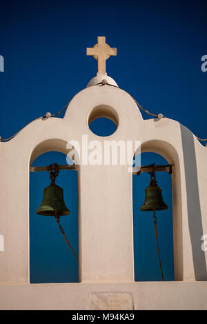 Einer weissen Turm der weißen Bögen, Kreuz und schwarz Glocken sitzt über die katholische Kirche in Oia, Santorini, Griechenland Stockfoto