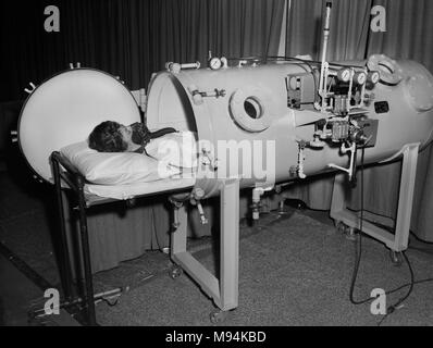 Ein medizinischer Techniker demonstriert eine neue Patienten hyperbare Sauerstofftherapie Kammer die amerikanische Hochschule der Chirurgen Kongress in Chicago, Ca. 1964. Stockfoto