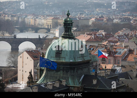 Nach Westen Blick von Letna Park im Stadtteil Hradschin und die Karlsbrücke über die Moldau, in denen die EU und die Tschechische Flaggen über eine Regierung Gebäude fliegen, am 18. März 2018, in Prag, Tschechische Republik. Wie Rom, Prag ist auf sieben Hügeln erbaut. Stockfoto