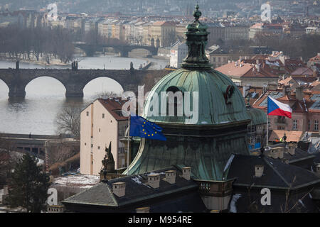 Nach Westen Blick von Letna Park im Stadtteil Hradschin und die Karlsbrücke über die Moldau, in denen die EU und die Tschechische Flaggen über eine Regierung Gebäude fliegen, am 18. März 2018, in Prag, Tschechische Republik. Wie Rom, Prag ist auf sieben Hügeln erbaut. Stockfoto