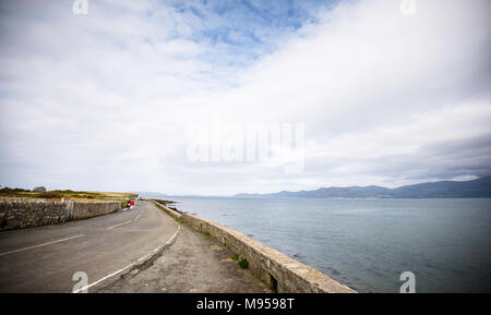 Am Straßenrand Parken mit Meerblick in der Nähe von Beaumaris, Anglesey, North Wales, UK. bewölkten Himmel und Landschaft Straße in der britischen Küste. Straße mit herrlicher Aussicht. Stockfoto