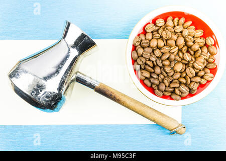 Metall Turk und Kaffeebohnen auf einem roten Schild auf einem blauen Hintergrund Stockfoto