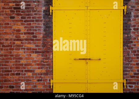 Gelb lackiertem Metall Tür und Wand Hintergrund Stockfoto