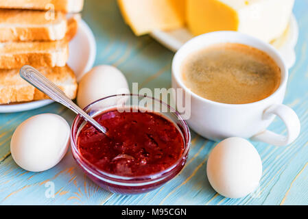 Frühstück mit Kaffee, Eier, Toast, Käse, Marmelade Stockfoto