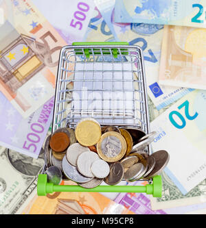 Warenkorb mit Münzen und Banknoten im Hintergrund. business Shopping Konzept Stockfoto