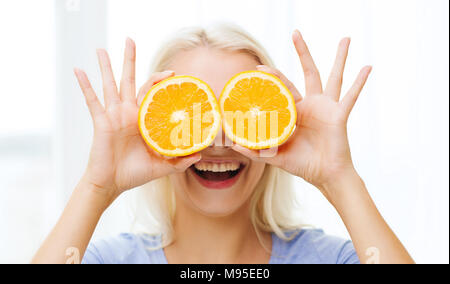 fröhliche Frau, die Spaß für Augen mit Orange Stockfoto