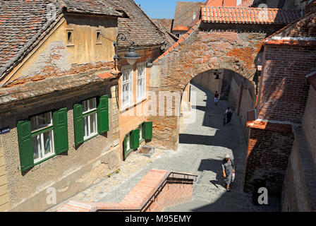 Sibiu, Siebenbürgen, Rumänien. Straße und Ziegel arch in der unteren Stadt. Pasajul Scarilor/Passage der Treppe Stockfoto