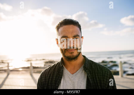 Porträt ein Mann stand in der Nähe der Küste. Mann, der an einem Urlaub in der Nähe von dem Meer. Stockfoto