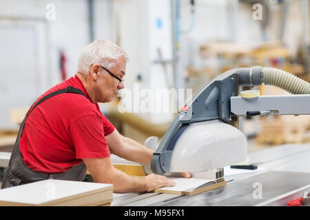 Tischler mit Plattensäge und Faserplatten im Werk Stockfoto