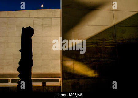 Eine Statue in Silhouette und Schatten gegen 2 Marmor Wände schaffen eine optische Illusion, die im Innenhof des CaixaForum. Stockfoto