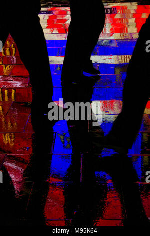 Touristische Silhouetten im Regen durchnässt Pflaster von Piccadilly Circus, London Stockfoto