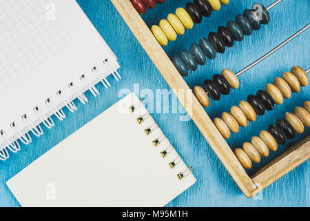 Holz- Abacus und einen Notizblock auf dem Schreibtisch in blauer Farbe Stockfoto