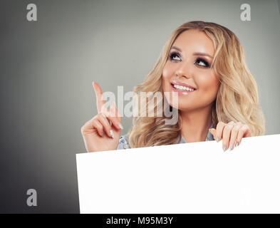 Nette junge Frau zeigt mit dem Finger oben gedrückt und Weißbuch Hintergrund Stockfoto