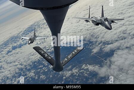 Ein Royal Netherlands Air Force F-16 und US Air Force F-15C Adler fliegen in Formation zusammen hinter einem US Air Force KC-135 Stratotanker während der Luftbetankung Training Mission März 21, 2018, über die Niederlande. Fast 260 Flieger aus dem 142 Fighter Wing, implementiert mit F-15-CS-Betrieb von Leeuwarden, Niederlande, als Teil einer Theater Sicherheit Paket zur Unterstützung der Operation Atlantic lösen. (U.S. Air Force Foto von älteren Flieger Luke Milano) Stockfoto