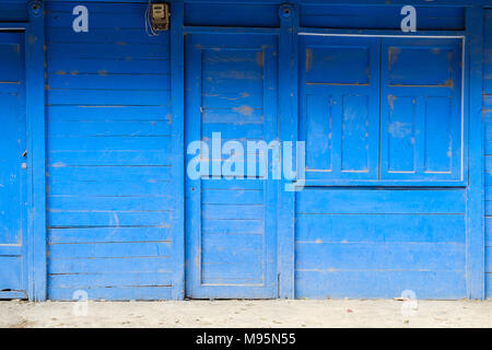 Vorderansicht eines blau lackierten Holz- Haus mit geschlossener Tür-, Fenster- und Shutter - Stockfoto