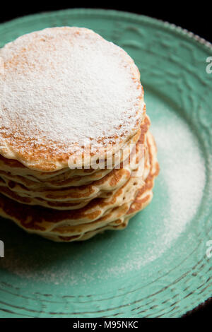 Amerikanische Pfannkuchen mit Zucker von oben auf ein Pastell grün rustikale Platte Stockfoto