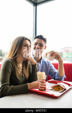 Paar in Liebe umarmen Spaß, zusammen mit einem Lächeln. Schöner Freund Witz ihrer Freundin und ihren Feed, Pommes frites. Stockfoto