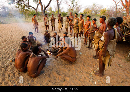 Ju/'Hoansi oder San Buschmänner in täglich rund um ein Lagerfeuer an ihrem Dorf, Grashoek, Namibia Stockfoto