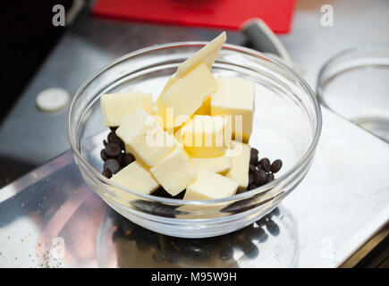 Schokolade Tropfen und die Butter in eine Schüssel geben. Stockfoto