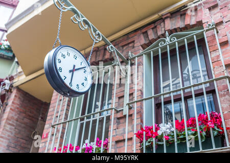Große vintage old clock hängen mit Kette auf einem Stein Fenster Stockfoto