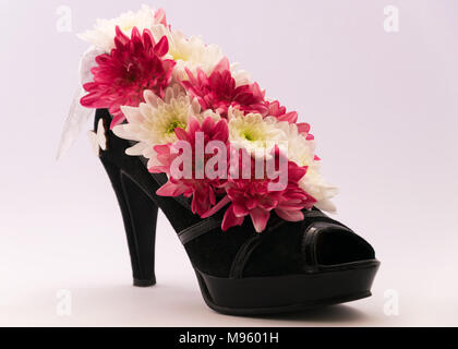 Blumenschmuck in der Frauen Schuhe mit hohen Absätzen. Ungewöhnliche, einzigartige und originelle Boxen für Blumen Stockfoto