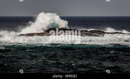 Wellen gegen Felsen am Loop Head an der Ostküste Irlands in der Grafschaft Clare Stockfoto