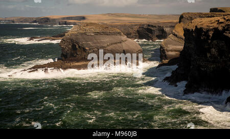 Wellen gegen Felsen am Loop Head an der Ostküste Irlands in der Grafschaft Clare Stockfoto