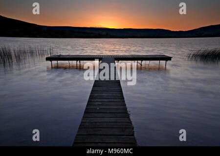 Holzsteg am Ufer des Lough Derg, County Clare, Irland bei Sonnenuntergang Stockfoto