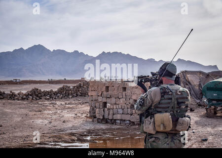 Afghanische Commando Scannen der Bereich durch den Rahmen seiner M16 Sturmgewehr außerhalb der Überreste einer afghanischen nationalen Verteidigungs- und Sicherheitskräfte Outpost hinter Farahrud Basar, direkt an der Hauptstraße in Bolo Bluk Bezirk, Provinz Farah. Nach den Kommandos, die Outpost hatte vor kurzem überfahren und durch die Taliban abgerissen, die das Dorf im Hintergrund halten. Eine Commando Betrieb das Dorf am gleichen Tag wieder zurückzunehmen, ist fehlgeschlagen. Der afghanischen Elite Streitkräfte - die Kommandos und die besondere Kräfte sind eines der wichtigsten Elemente in der Afghanische und US-Strategie die Schleifen figh zu drehen Stockfoto