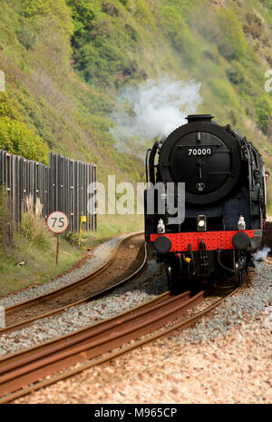 BR Standard Pacific No 70000 Britannia schleppt den Dartmouth Express am 15.. Mai 2015 neben die Meeresmauer von Teignmouth. Stockfoto