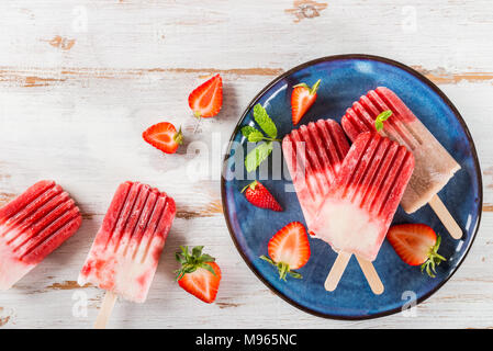 Hausgemachte Vegan Erdbeere Popsicle aus Erdbeersaft und Kokosmilch auf hellen Hintergrund. Sommer essen Konzept. Ansicht von oben. Stockfoto