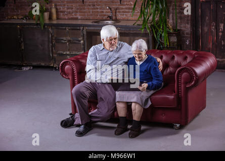Senior Paar mit Laptop auf der Couch zu Hause sitzen Stockfoto