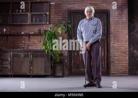 Portrait von älteren Mann mit Stock zu Hause Stockfoto