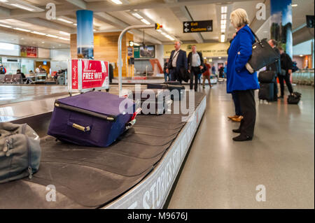 Menschen für ihr Gepäck an der Gepäckausgabe Karussell in Cork Airport, Cork, Irland wartet. Stockfoto