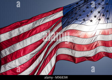 Ein großes, hintergrundbeleuchtetes amerikanische Flagge weht im Wind Stockfoto