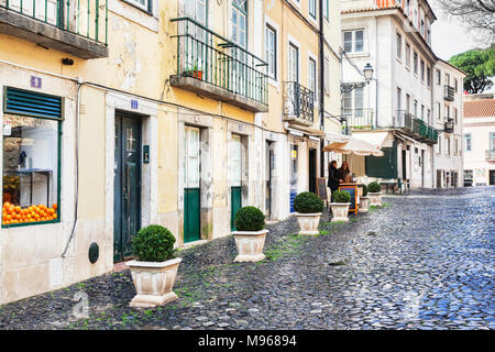 1. März 2018; Lissabon, Portugal - eine typische Straße in der Altstadt von Lissabon, in der Nähe der maurischen Burg, mit portugiesischen Pflaster. Stockfoto